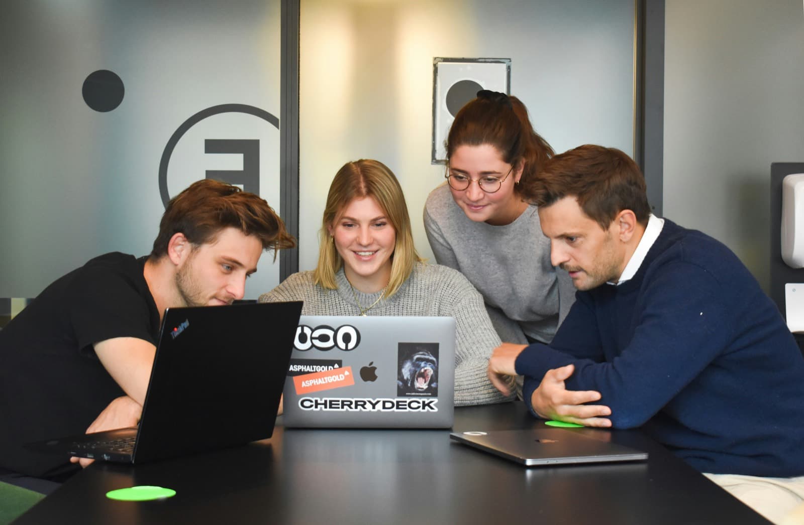 The team gathered around a laptop in the studio